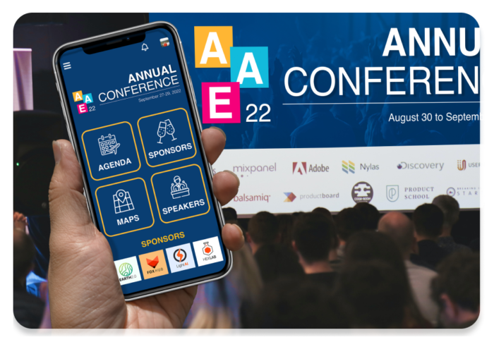 Mobile phone with event app held up with crowd viewing matching live display on conference screen