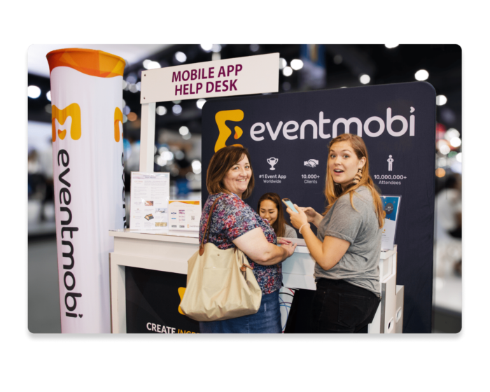 Event attendees standing in front of the EventMobi on-site support help desk