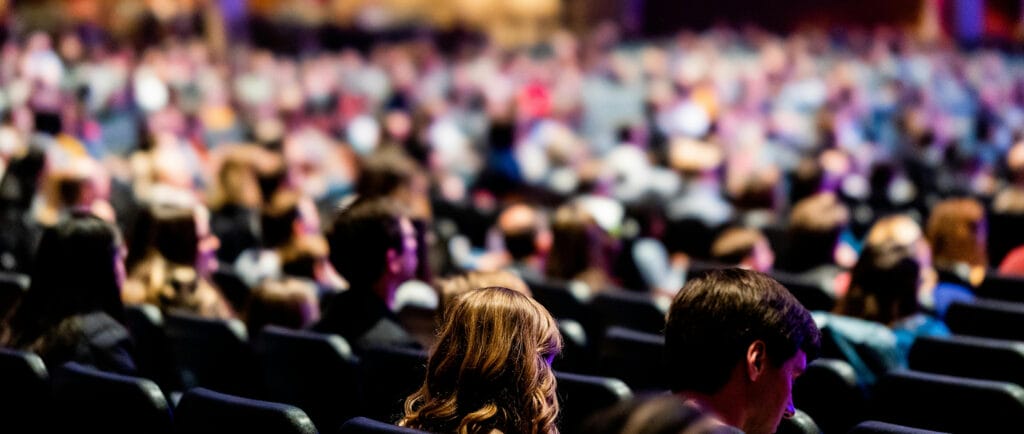 Attendees at an auditorium listening to a conference of an event.